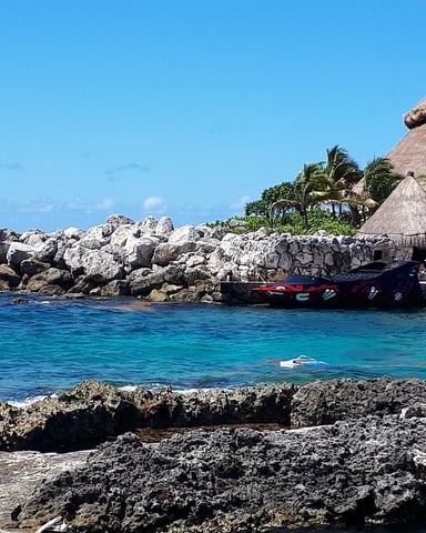 Riviera Maya cove with thatched palapas and turquoise water